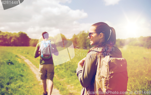 Image of happy couple with backpacks hiking outdoors