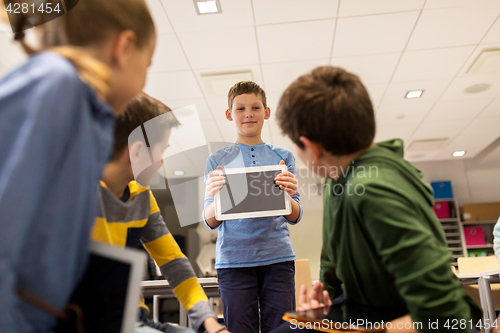 Image of group of happy children with tablet pc at school