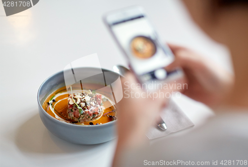 Image of woman with smartphone photographing food at cafe