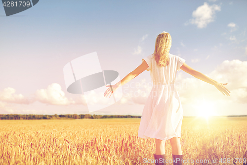 Image of happy young woman in white dress on cereal field