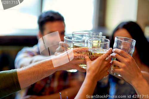 Image of happy friends drinking beer at bar or pub