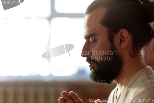 Image of close up of man meditating at yoga studio