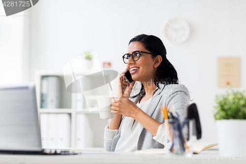 Image of businesswoman calling on smartphone at office