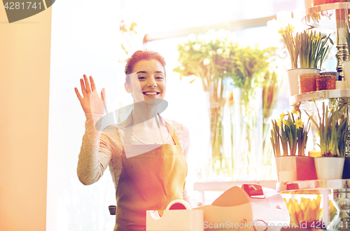 Image of smiling florist woman at flower shop cashbox