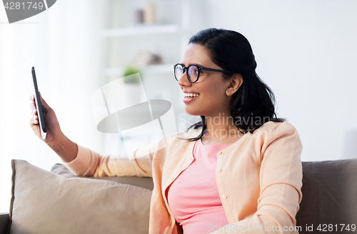 Image of happy indian woman with tablet pc at home