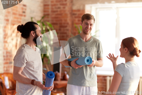 Image of group of people with mats at yoga studio or gym