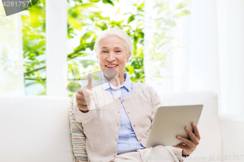 Image of senior woman with tablet pc showing thumbs up