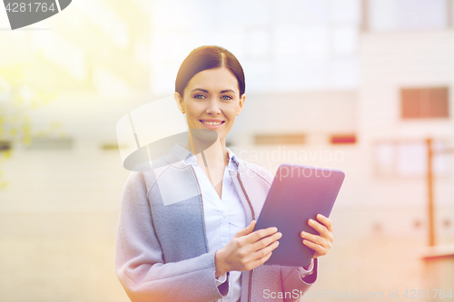 Image of smiling business woman with tablet pc in city