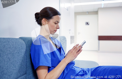 Image of female doctor or nurse with smartphone at hospital