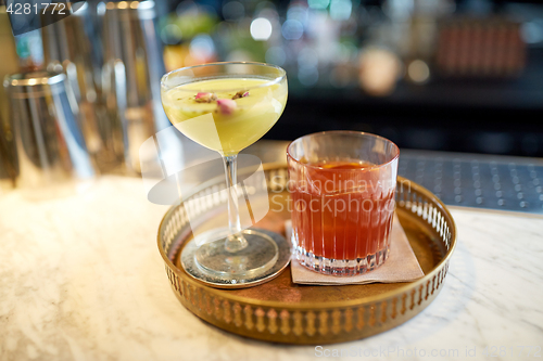 Image of tray with glasses of cocktails at bar