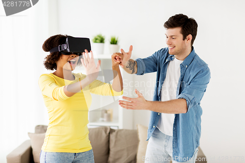 Image of happy couple with virtual reality headset at home
