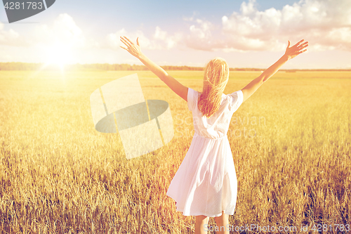 Image of happy young woman in white dress on cereal field