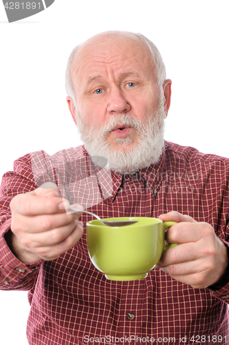 Image of Cheerfull senior man with green cup and teaspoon, isolated on white