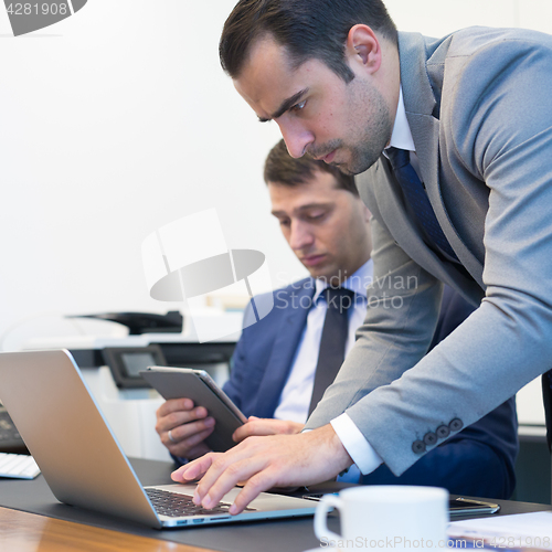 Image of Business team remotely solving a problem at business meeting using laptop computer and touchpad.