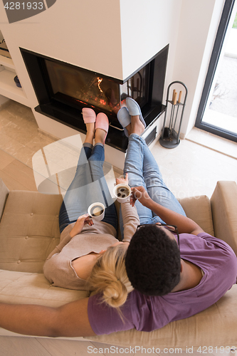 Image of Young multiethnic couple  in front of fireplace