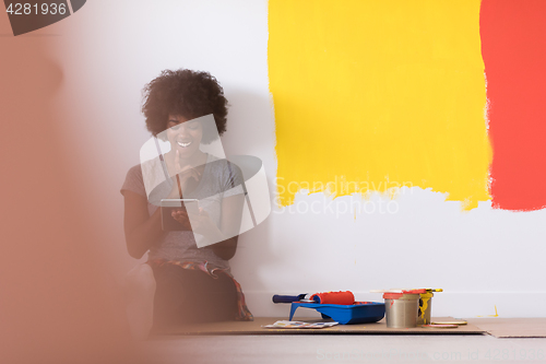 Image of back female painter sitting on floor