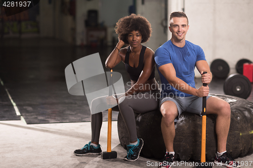 Image of multiethnic couple after workout with hammer