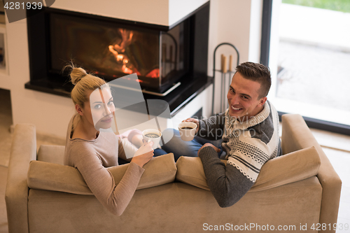 Image of Young couple  in front of fireplace