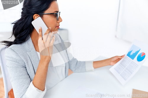 Image of businesswoman calling on smartphone at office