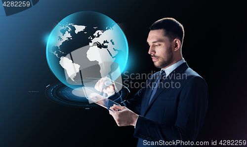 Image of businessman with tablet pc and earth projection