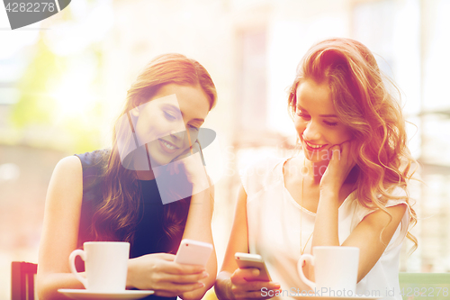 Image of women with smartphones and coffee at outdoor cafe