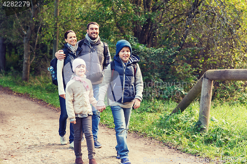 Image of happy family with backpacks hiking in woods