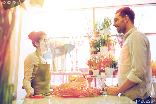 Image of smiling florist woman and man at flower shop