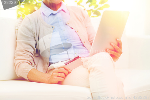 Image of senior woman with tablet pc and credit card