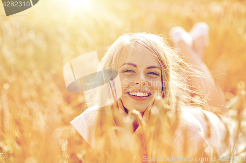 Image of happy woman or teen girl lying in cereal field