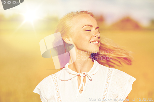 Image of smiling young woman in white on cereal field