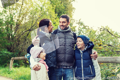 Image of happy family with backpacks hiking