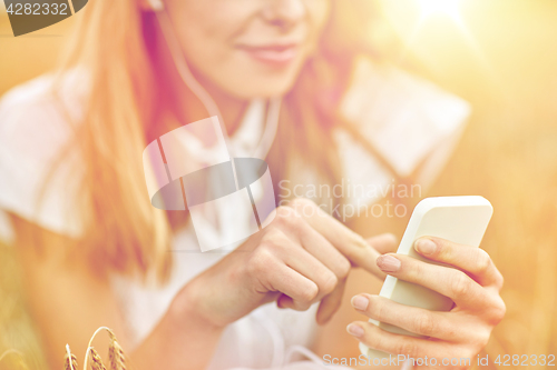 Image of close up of woman with smartphone and earphones