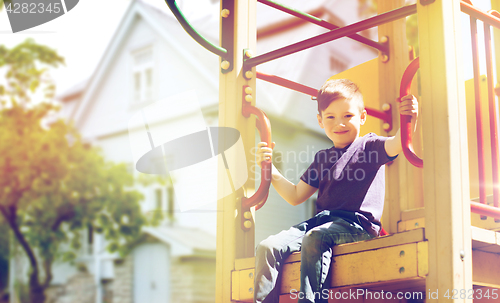 Image of happy boy on children playground climbing frame