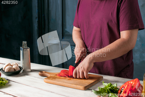 Image of Closeup hand of chef baker making pizza at kitchen