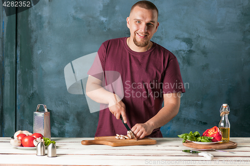 Image of Closeup hand of chef baker making pizza at kitchen