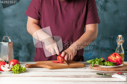 Image of Closeup hand of chef baker making pizza at kitchen
