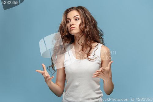 Image of Portrait of an angry woman looking away on a blue background