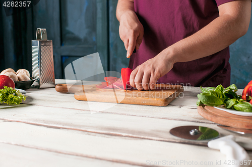 Image of Closeup hand of chef baker making pizza at kitchen