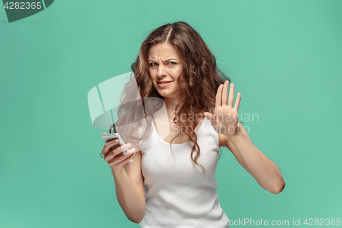 Image of The portrait of disgusted woman with mobile phone