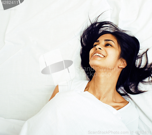 Image of young pretty tann woman in bed among white sheets having fun, tr