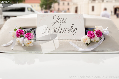 Image of White wedding limousine decorated with flowers