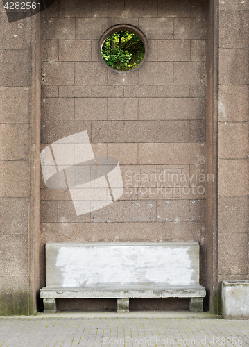 Image of Ancient stone bench near the big brick wall