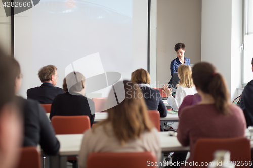 Image of Woman giving presentation in lecture hall at university.