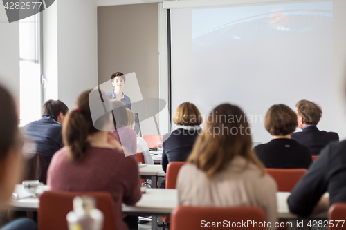 Image of Woman giving presentation in lecture hall at university.