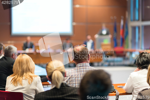 Image of Public speaker giving talk at business event.