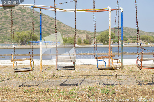 Image of old swings in playground near the sea