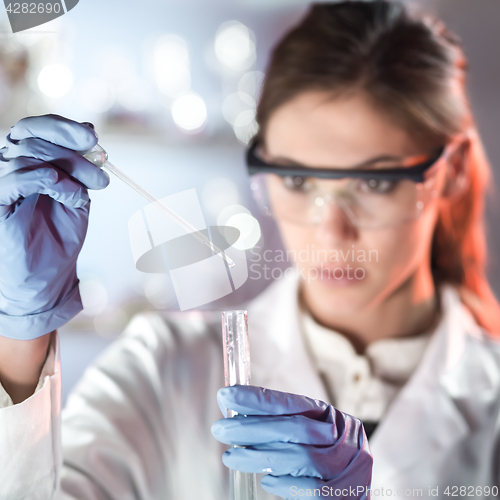 Image of Young scientist pipetting in life science laboratory.