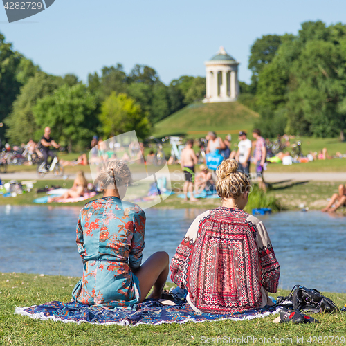 Image of People tanning, swimming and enjoying the summer in Englischer Garten in Munich, Germany.