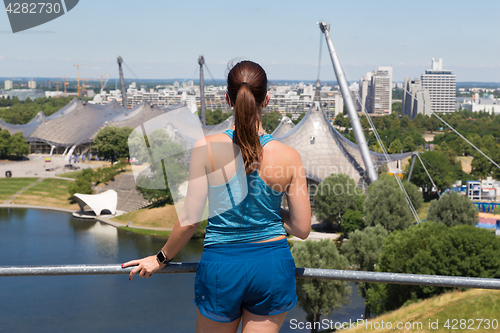 Image of Sporty woman enjoying the view over Munich olympic park.