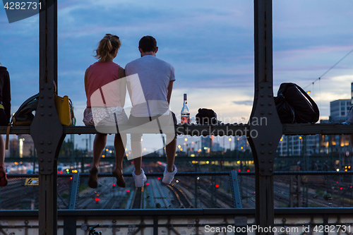 Image of Young couple on romantic date on urban railway bridge, Munich, Germany.